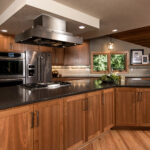 A completely remodeled new modern craftsman kitchen in Portland featuring beautiful wood tones along with entertainment bar