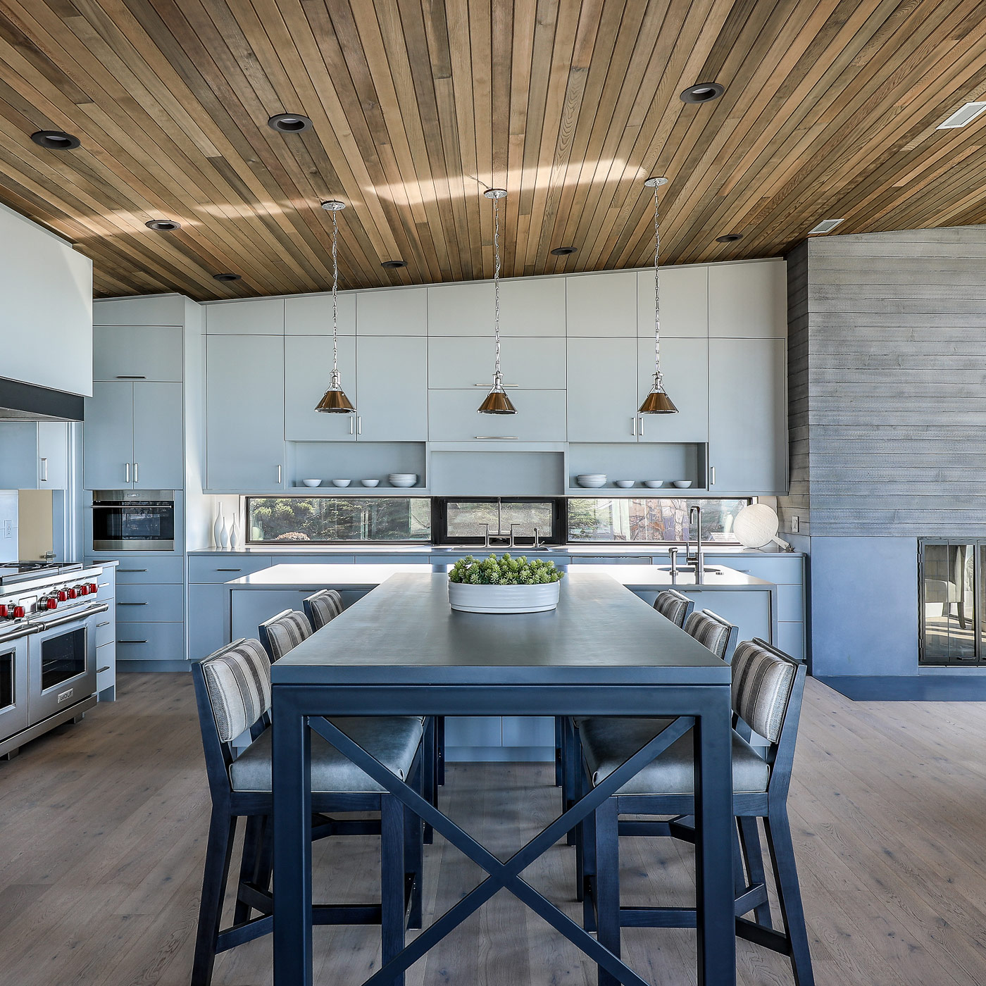 bright mid century modern kitchen on the Oregon coast with flat panel cabinets, quartz countertops, and open layout facing the beach