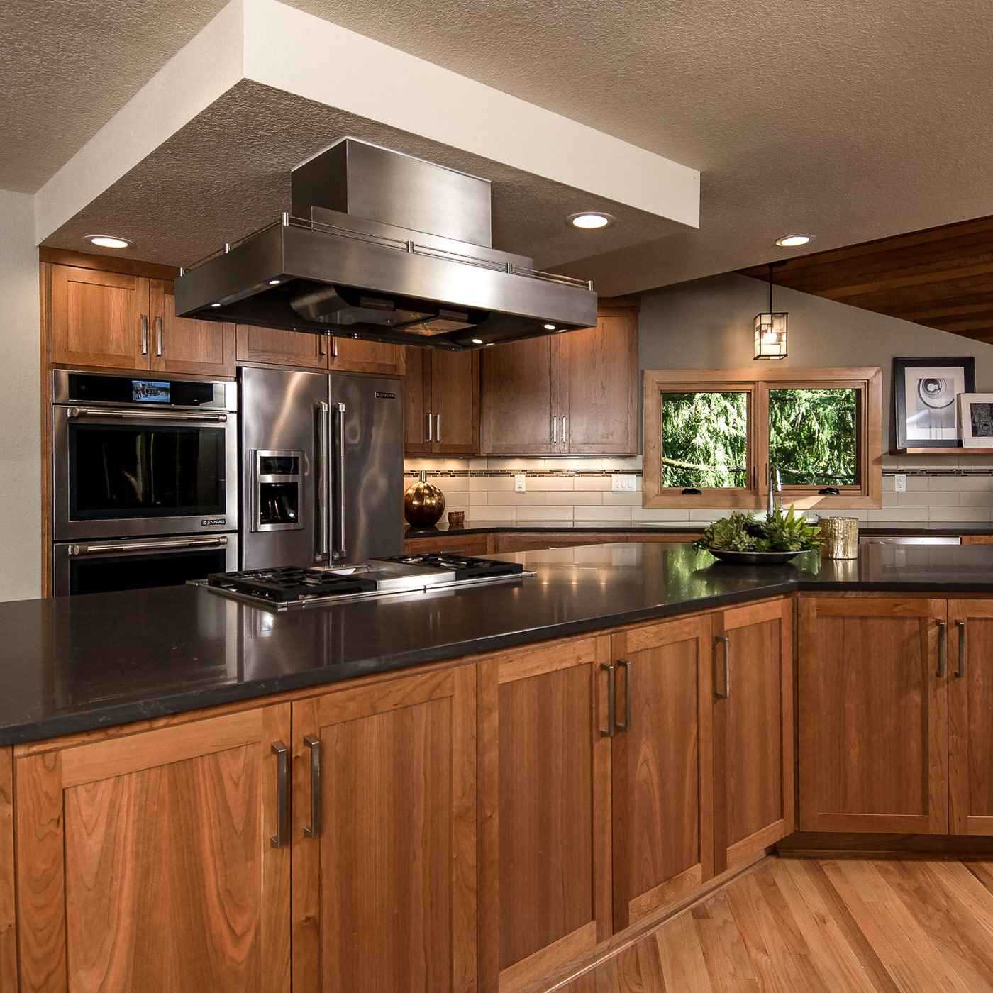 A completely remodeled new modern craftsman kitchen in Portland featuring beautiful wood tones along with entertainment bar