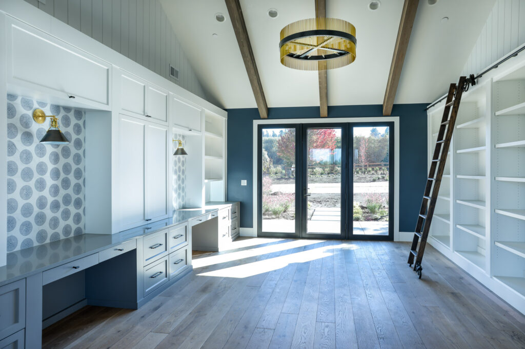 modern farmhouse bonus room in whites and blues with book shelves and ladder