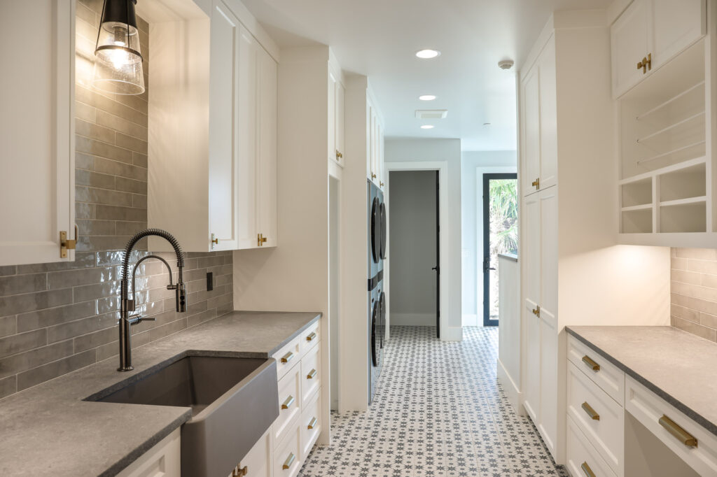 modern farmhouse laundry room with white cabinets and gold hardware