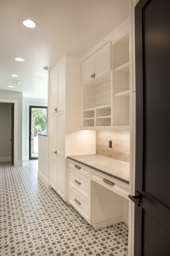 modern farmhouse laundry room with white cabinets and desk area
